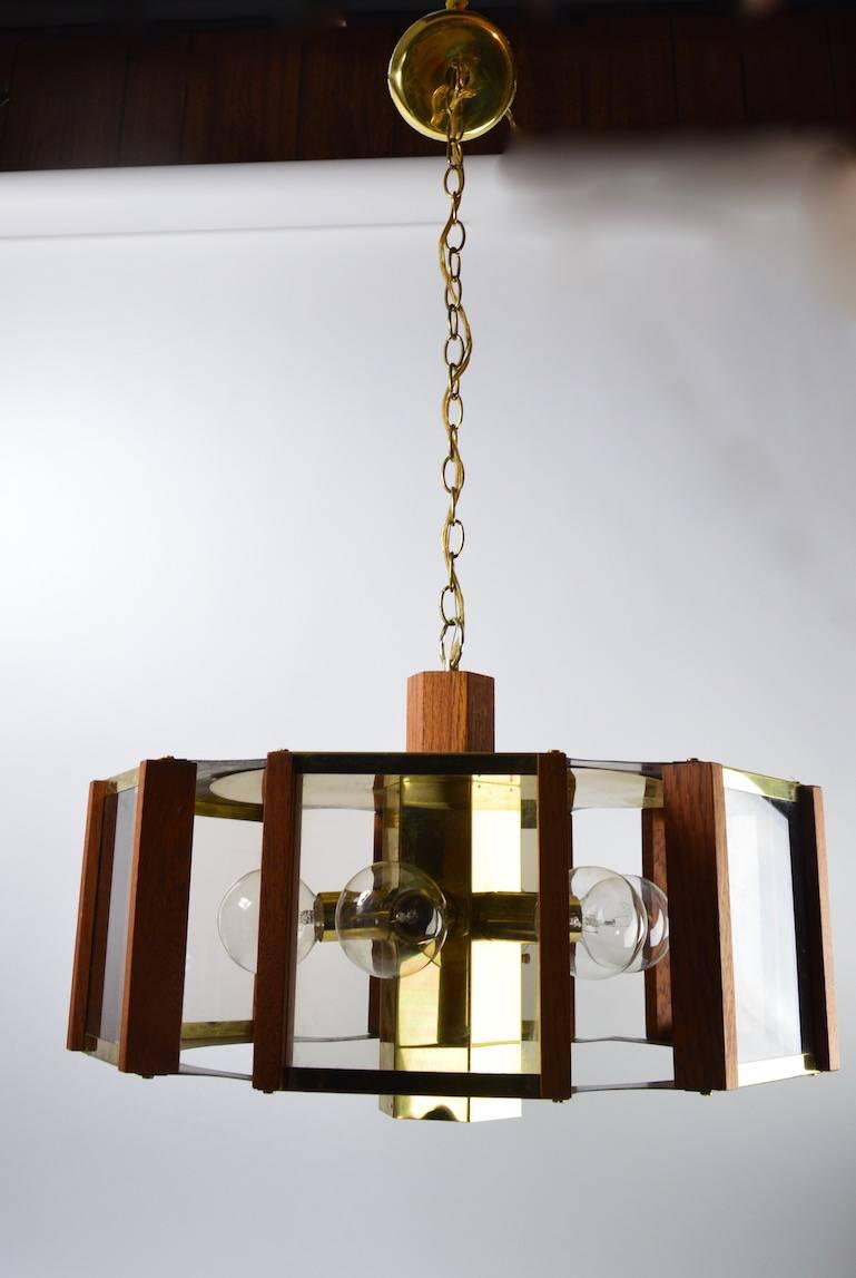 Brass trim wood, and grey Lucite hexagonal chandelier by Farederick Ramond. This fixture has a center downlight bulb in addition to the exposed side light bulbs. Clean, original, working condition showing some light cosmetic wear, normal and