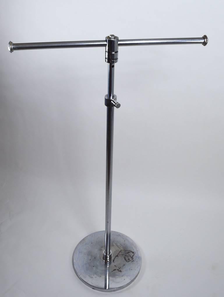 Art Deco chrome and black adjustable clothes rack. The clothes rack can be raised to 73.5” H or lowered to 48
