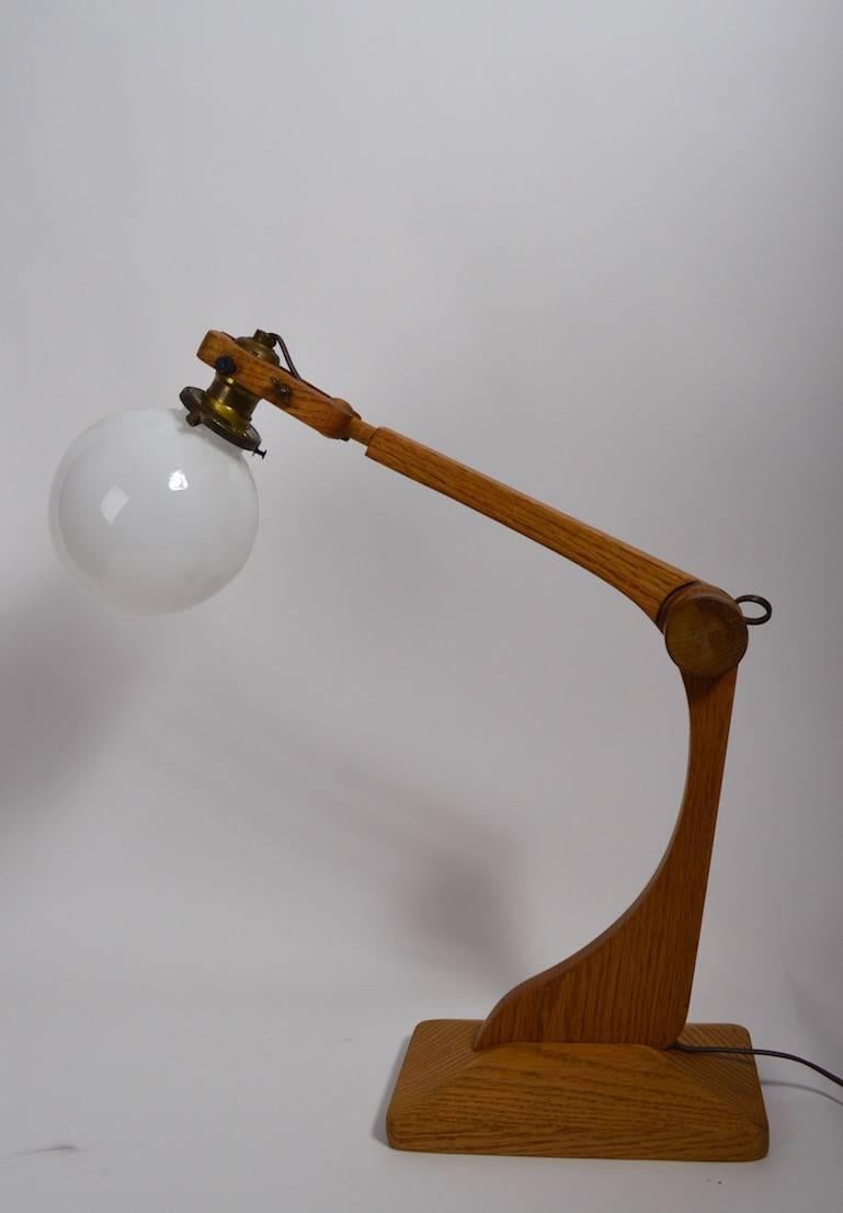 Probably Danish or possibly Swedish or Norwegian made adjustable desk, work lamp with original glass ball shade. This example is clean, and working, currently wired for US use. The arm bottom arm is 13
