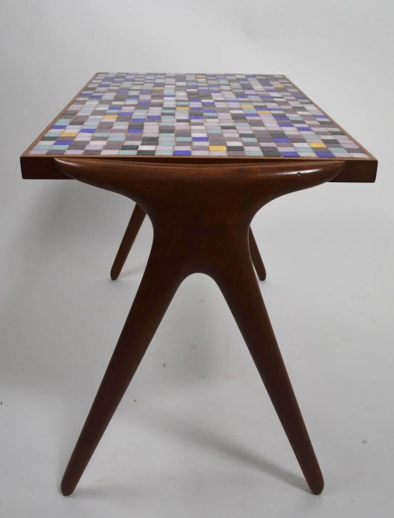 Multi colored mosaic tile top on sculpted wood base, side table by Kagan Dreyfuss. This example is in very good original condition, one small bruise to the wood legs, as shown.