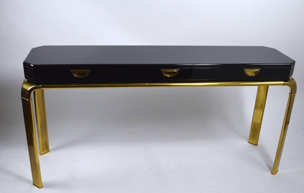 Very stylish, chic, and well crafted John Widdicomb for Mastercraft console table. This example has a black lacquer three drawer top, with brass pulls, and heavy cast brass base. 
 Excellent, clean, original condition, ready to use.