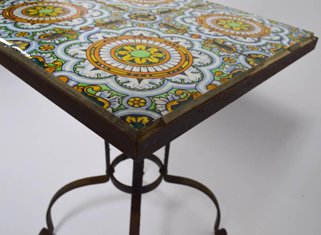 Nice tile-top table with wrought iron base. Obvious Moorish influence, possibly Catalina or Laguna production. The tiles and base are in very good vintage condition, some grouting along the outer edges is missing, the tiles are securely in position.