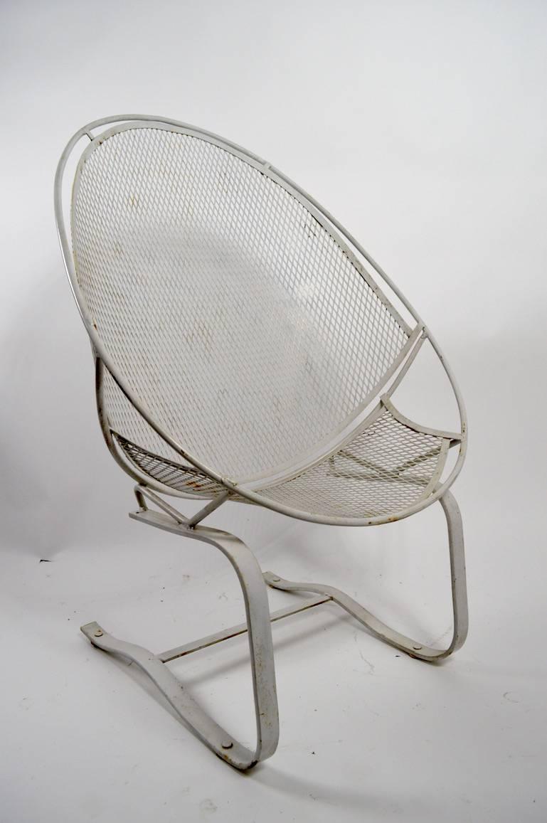 Classic Salterini high back cantilevered metal mesh and steel rod chair. This example is in white finish, which shows minor cosmetic wear. No damage, welds, or repairs. Suitable for indoor or outdoor use.