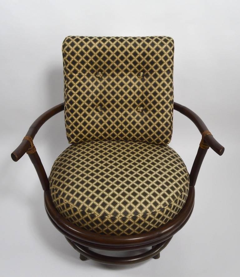 Paire de chaises pivotantes inhabituelles en bambou. Finition foncée d'origine, rembourrage d'origine, montre une légère usure, normale et conforme à l'âge.