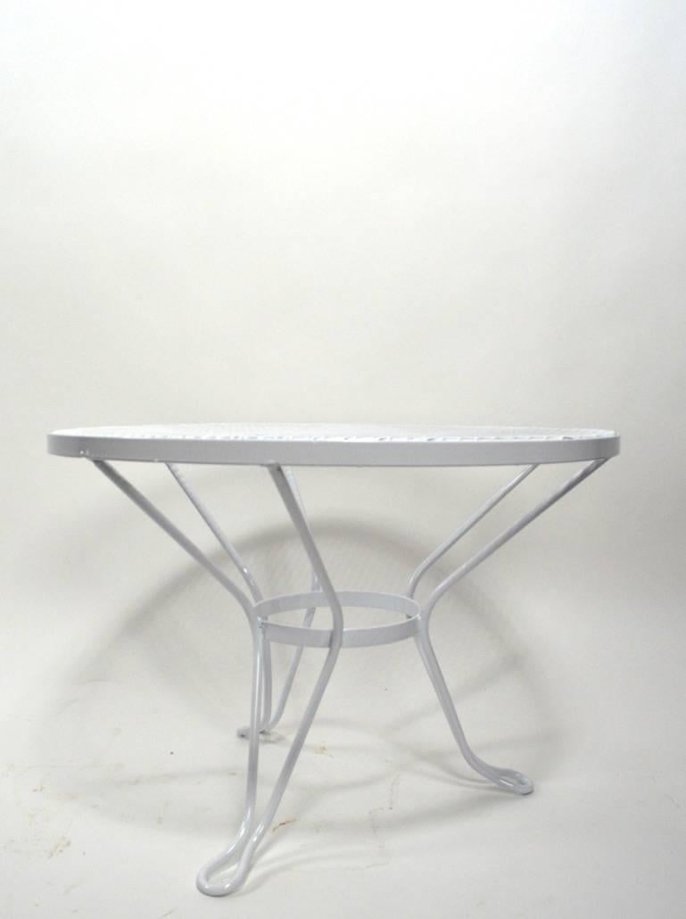  Woodard table, has recently been powder coated white and is in excellent condition. Metal mesh top, wrought iron legs. Suitable for indoor, or outdoor use, custom powder coating available if you do not want white.