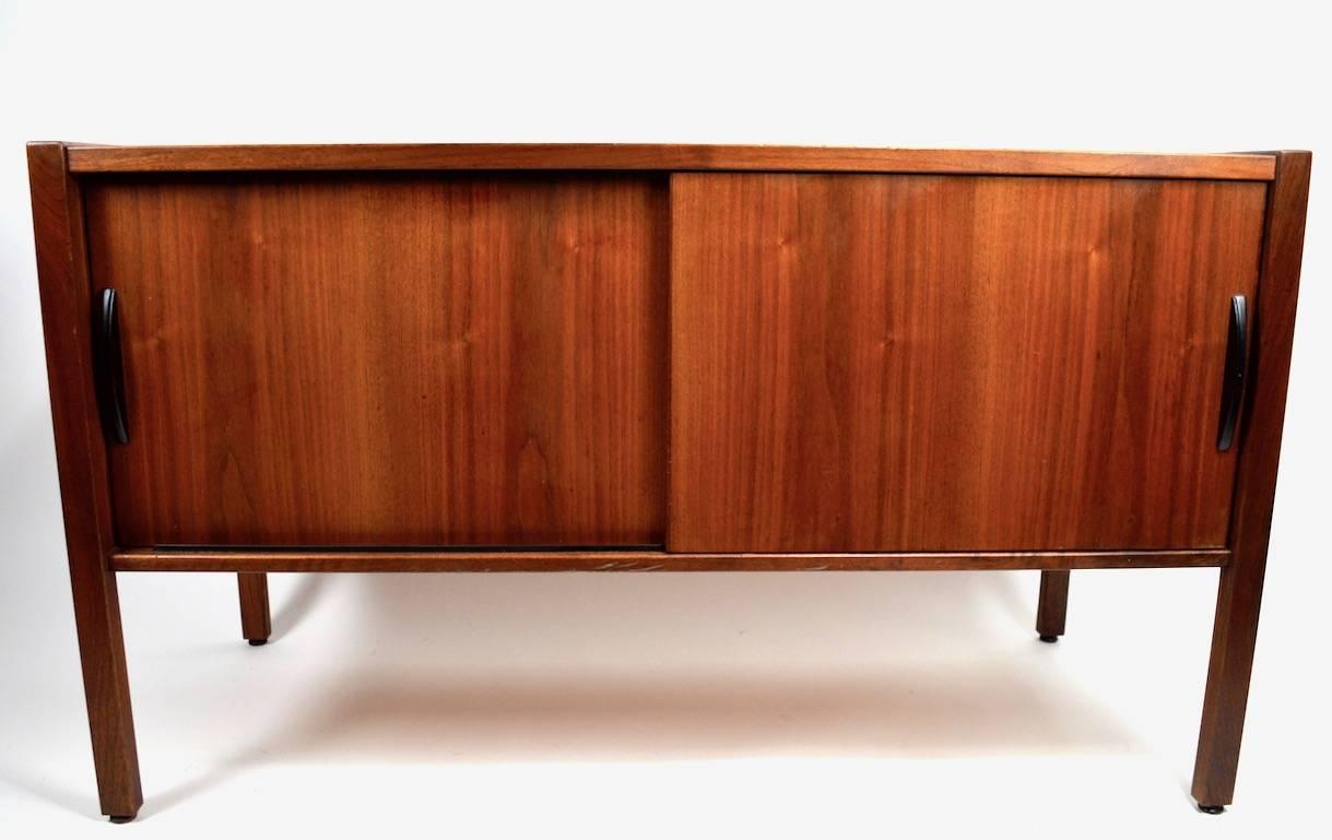 Nice Mid-Century credenza, sideboard with two sliding door which open tom reveal shelved storage. This cabinet was designed by Jens Risom, it is in very good original condition showing only minor cosmetic wear, normal and consistent with age. Good