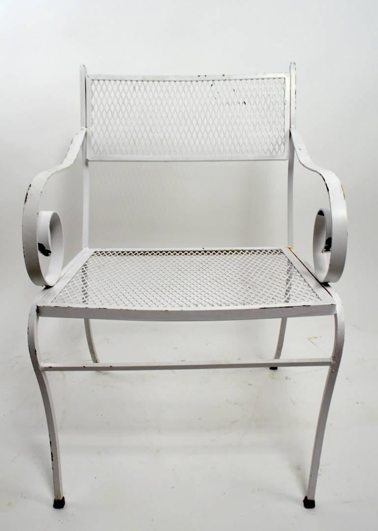 Wonderful set of ten matched dining height armchairs by Woodard.
 Each chair has a dramatic scroll form armrest, hand-wrought from, mesh seat and backrest.
Currently in old white paint finish, which shows age appropriate wear. Usable as is, or we