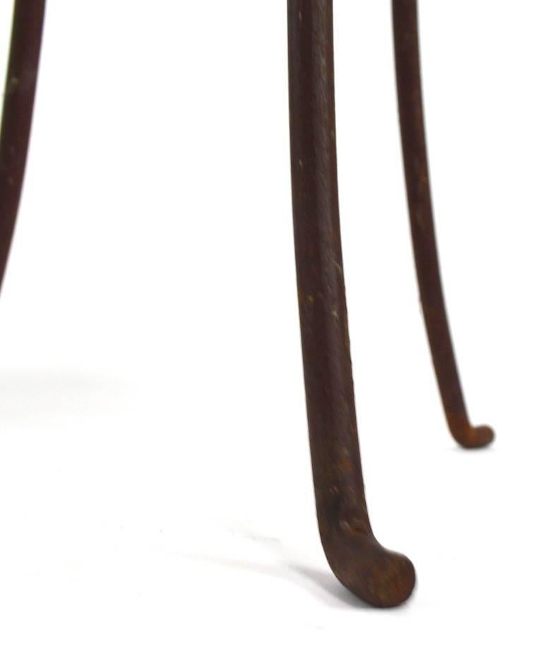 Interesting wrought iron stand with inset pebble stone top. The three leg base shows distinct Art Nouveau influence.
