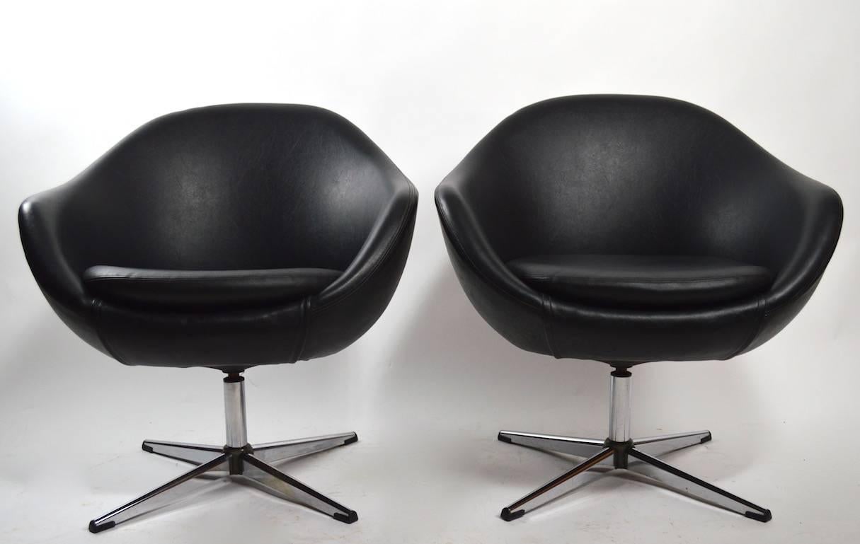 Stylish pair of swivel pod chairs by Overman. Both are in very good original condition, one shows minor pitting to the chrome legs, as shown. Selling and priced as a pair.