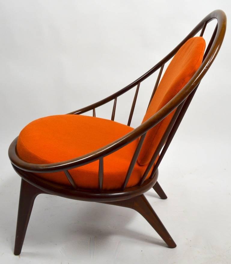 This is the earlier version of the classic hoop, or peacock chair by Ib Kofod-Larsen. The frame is in excellent, original condition, the cushions show some wear, the back rest cushion is a bit crunchy as the interior foam has dried. Marked on verso.