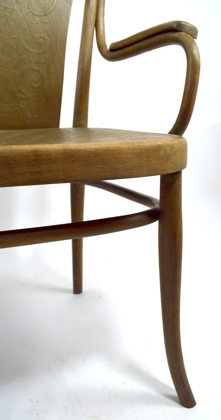 Unusual bentwood settee, bench by Thonet. This example has an embossed pressed wood back and seat, the finish is weathered, the frame shows some wear including a glue repair to the back of the lower oval stretcher. Measures: Arm H 26.
Chic and