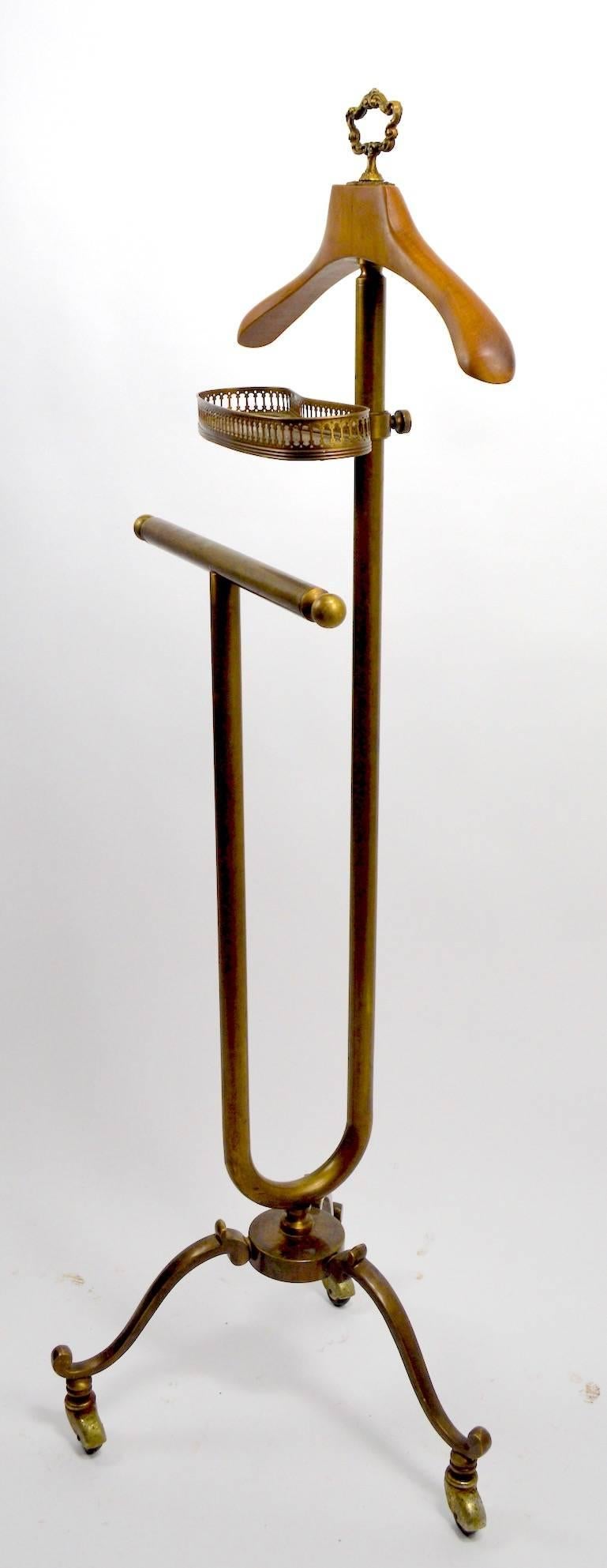 Classy brass and maple valet, dressing stand, silent butler, with adjustable change, key tray, on tri-part leg stand. Manufacture attributed to Maison Jansen, Italy, circa 1970s. Measures: Height of lower rod 33