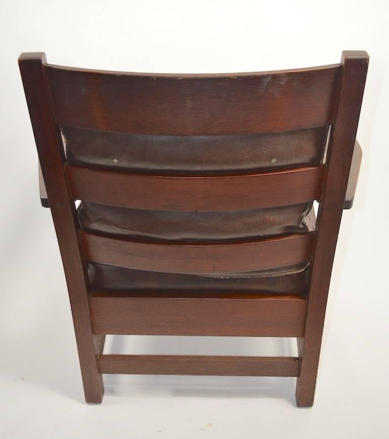 Nice Arts & Crafts Mission armchair by L.. & J.G. Stickley, in original finish, finish shows cosmetic wear, normal and consistent with age. The seat cushion is original, however has been recovered at some point, the back cushion is original. Chair