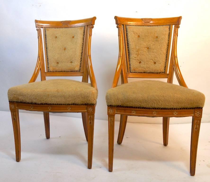 Elegant set of dining chairs by Grosfeld House in the Hollywood Regency, Neoclassical style. Currently in original upholstery, which shows wear. Hand-carved wood frames and tied spring seats exhibit the top quality workmanship expected from Grosfeld