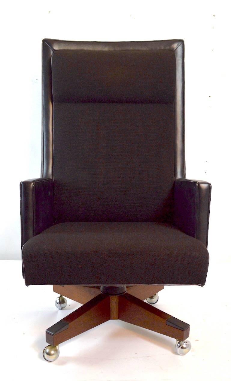 Executive high back leather and fabric swivel desk chair. The chair has a flex backrest, which tilts back when you recline. The seat if black tweed fabric, with black leather arms and back, as shown. Great quality design and construction, chair