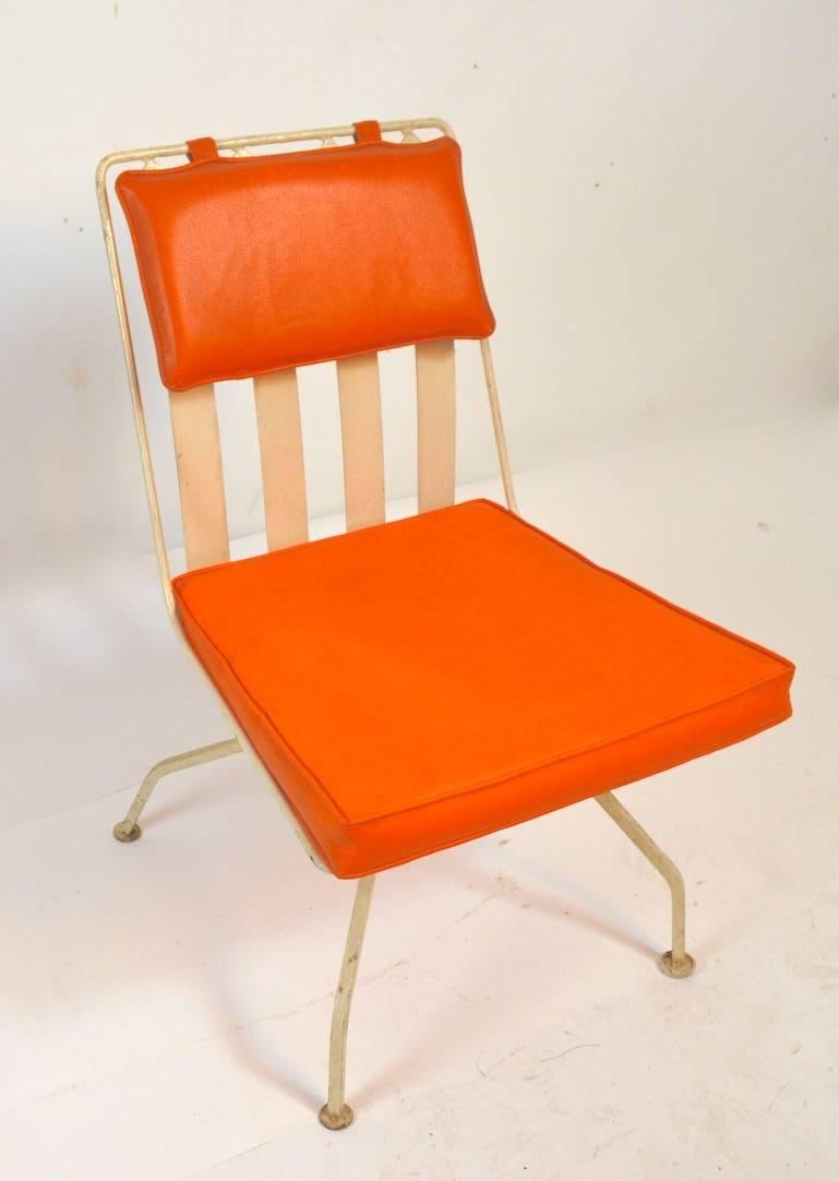 Unusual metal frame chair with orange vinyl pad seats. Please view the matching large sofa we have listed from this stylish set. Attributed to Woodard Furniture.