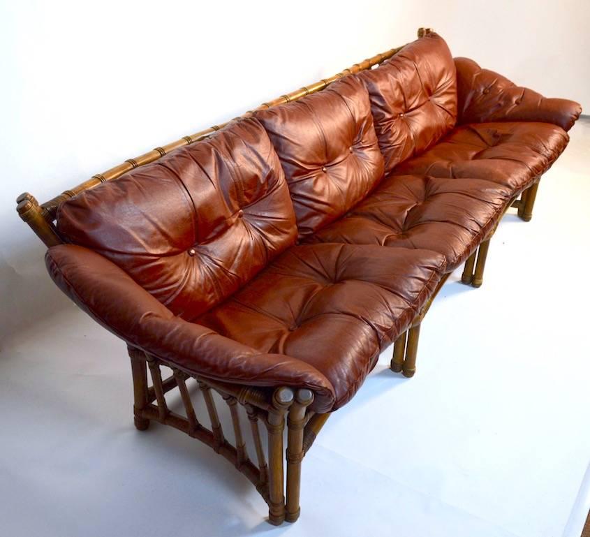 Unusual wood frame (Ash we believe) with rattan wrapping at the joinery, with original fitted leather cushions. Very chic, stylish and comfortable, overall excellent condition. The rattan wrap at the front bottom of the centre leg shows some minor