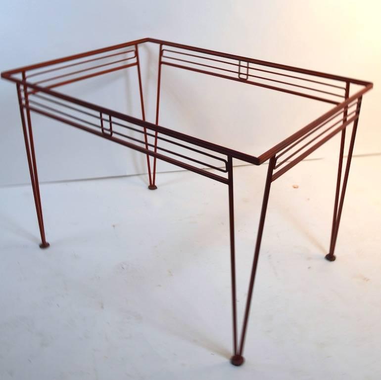 Nice Modernist patio, garden wrought iron dining table attributed to Salterini. This example is selling without the glass inset top. The table is currently in a later red paint finish, usable as is or we offer custom powder coating if you prefer
