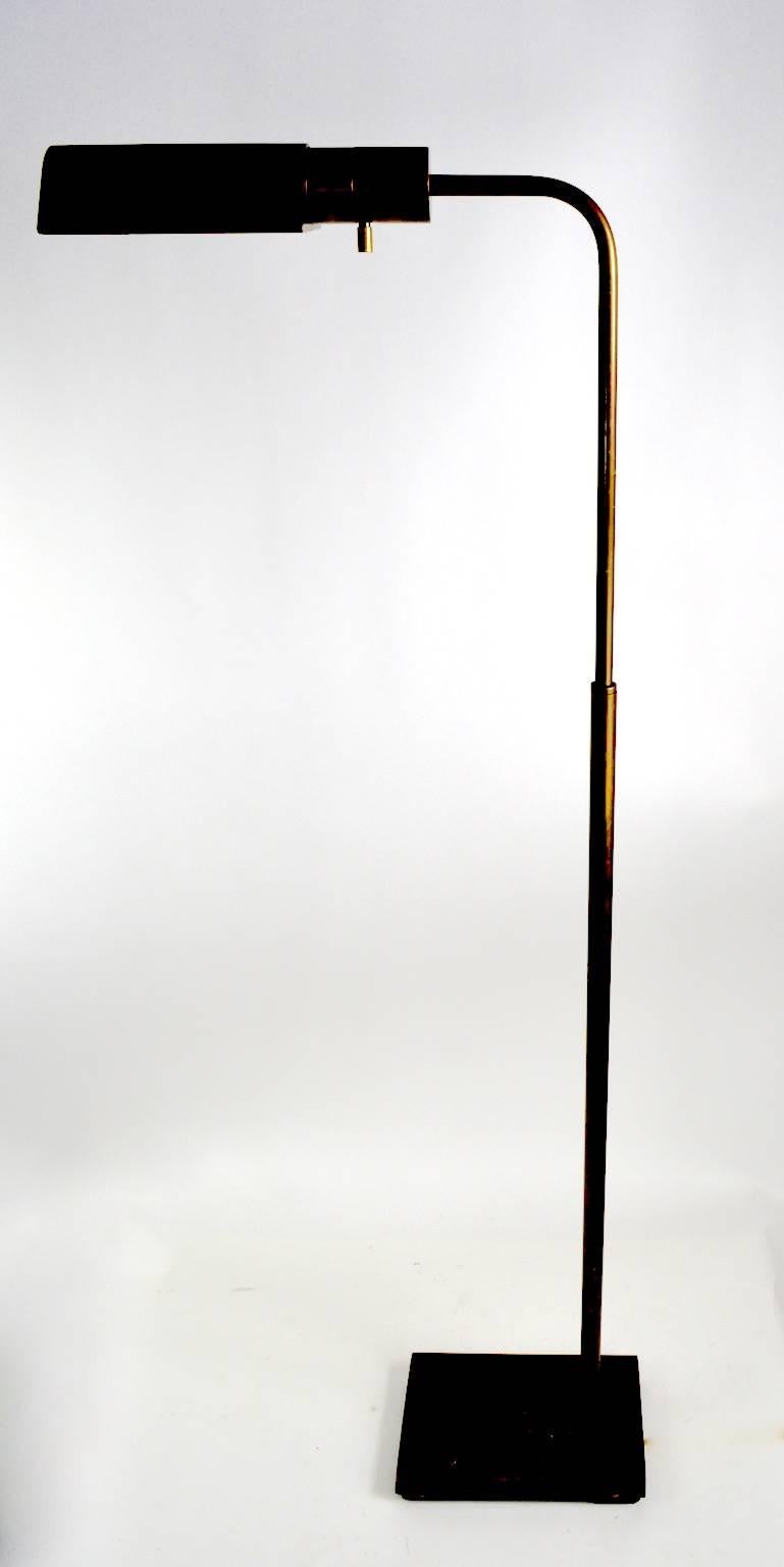 Adjustable brass floor pharmacy, or reading lamp in the style of Hartman, Koch and Lowy, etc. This example adjusts in height (lowest position 33 inches, highest position 48 inches) and the hood shade pivots to direct the light. The socket accepts
