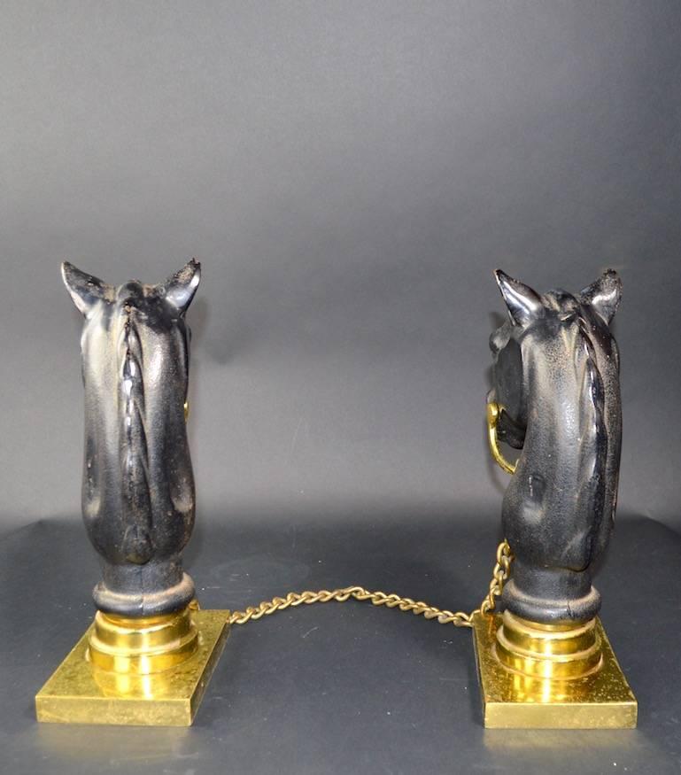 Cast iron horse heads, with brass bit, chain, and plinth bases. Each andiron 12.75 inches H x 4.25 inches W (at base) x 6.25 inches deep (at base). Clean and ready to use.
    