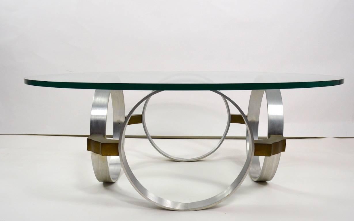 The base of this coffee table is of alternating aluminium rings and brass fittings, which supports the original round plate glass top (75 inch thick).
Clean, original, ready to use condition, design after Paul Mayen for Habitat.
 