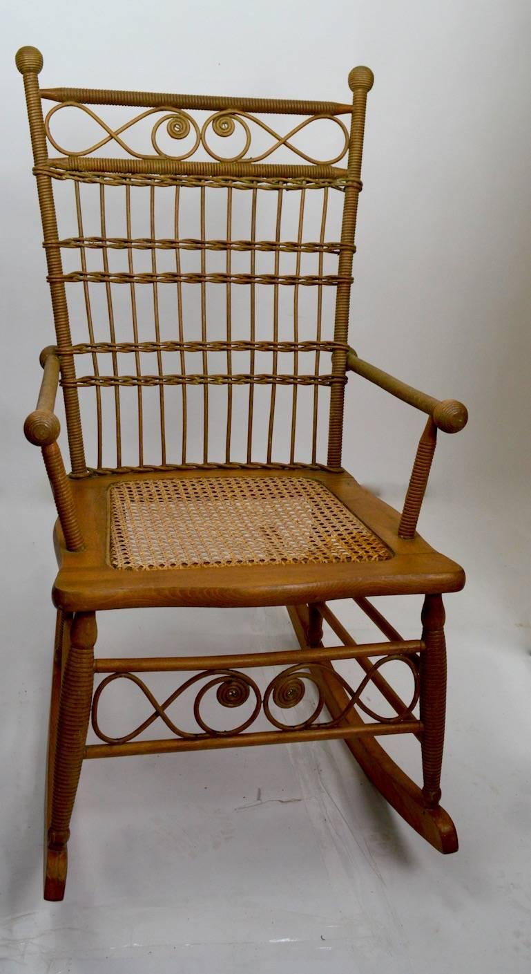 Victorian wicker rocking chair, with architectural stick and ball structure.
Measures: Arm height 24.
   