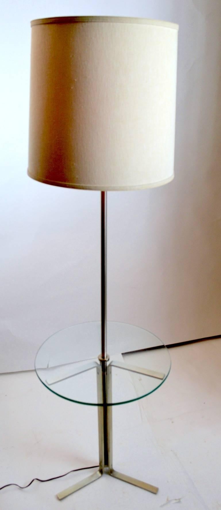 Modernist design and construction combination floor, table lamp. This example has an aluminium frame with a circular plate glass disk table surface. Table surface height 22 inches. Clean, working condition, shade not included.