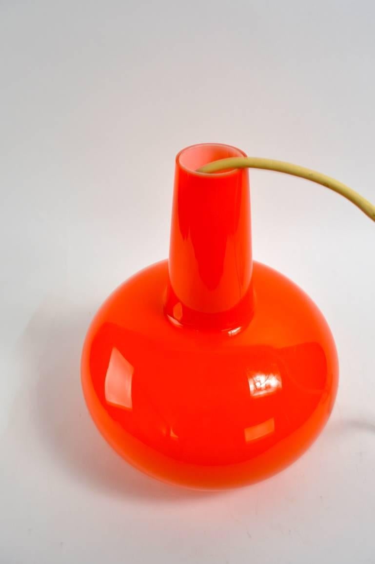 Orange cased glass pendant light in teardrop form. We have a pair of these, offered and priced individually.
 Each fixture comes with original canopy and cord (approximately 38 inches of cord).
 
