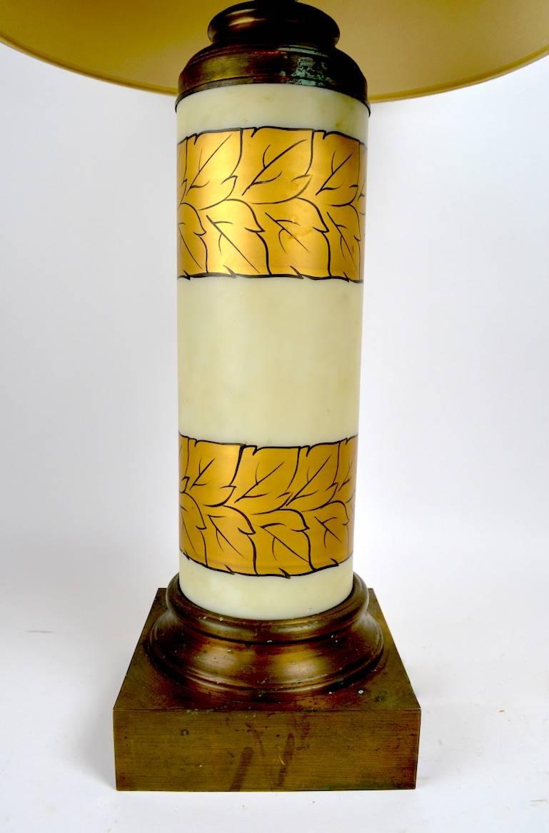 Cylindrical frosted white glass with gold foliate decoration, on brass bases. These lamps show some cosmetic wear and oxidation to the finish, notably on the bases and tops, as shown. Working, original condition, shades not included.