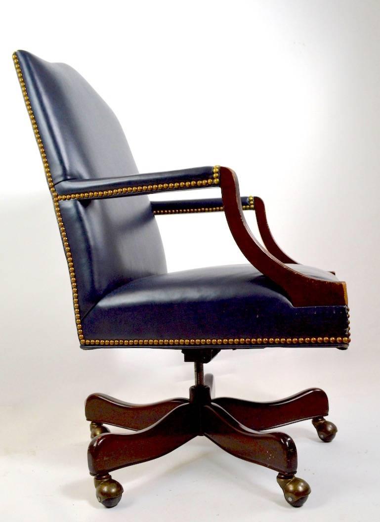 Classical style leather upholstered mahogany frame office, desk, executive chair by Hancock and Moore. Swivel, tilt model, arm height 27.5 inches seat height 18 inches. This example shows some signs of age and use, as shown.