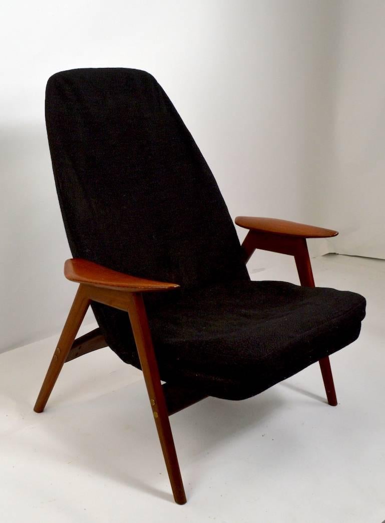 Rare example, high back lounge chair, made by P.I. Langlos Fabrikker AS Stranda Norway Westnofa. Solid teak frame supports tweed upholstered continuous seat and back. Arm height 20 inches x Seat height 14. This chair will need to be reupholstered,