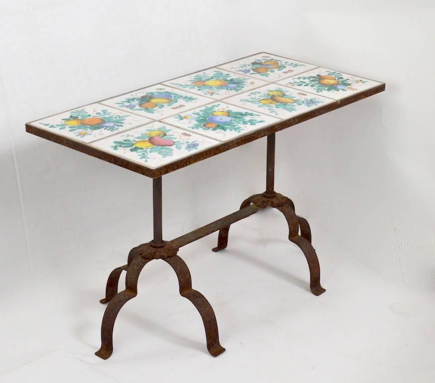 Wonderful decorative tile-top table, with hand wrought iron base. Thew metal base shows surface rust, normal and consistent with age and outdoor use. Unusual size, top consists of eight square majolica tiles, all free of damage.
Table suitable for