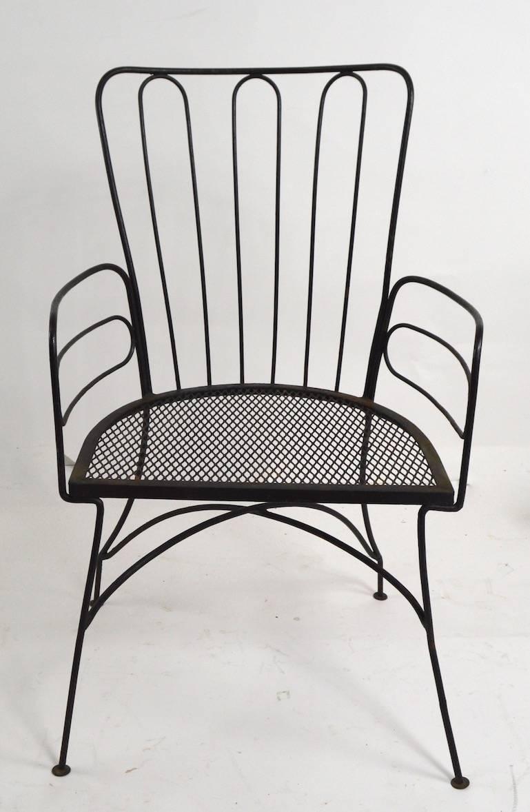 Stylish midcentury wrought iron armchair design after Weinberg, or Umanoff, probably manufactured by Woodard. Measures: seat H 16.5 arm H 25.
Suitable for indoor or outdoor use. Paint finish shows some cosmetic wear, normal and consistent with age.