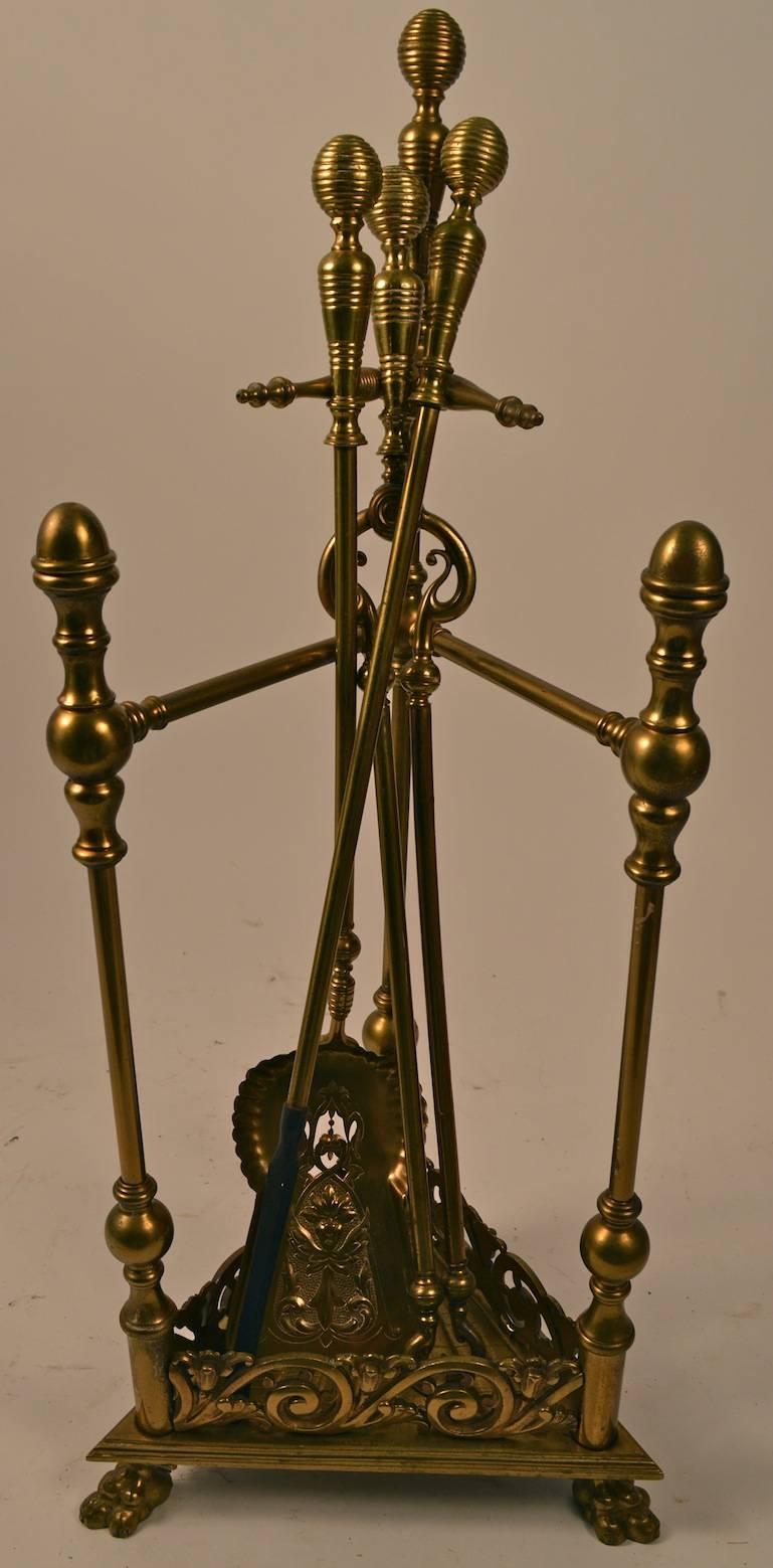 Unusual triangular form brass fireplace tool set. Set includes a stand,  poker, shovel, and tongs. Probably English, Victorian period set, hard to find complete sets still intact and together. Dimensions in listing are for the stand, shovel 25.5