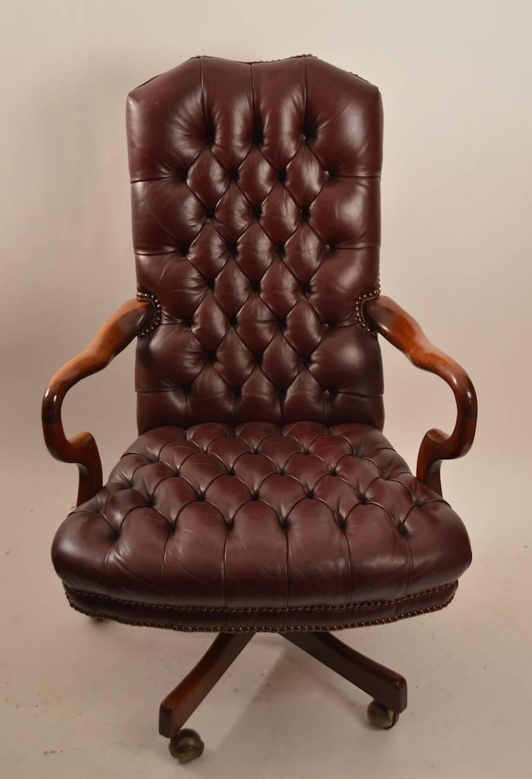 Classic high back, swivel, tilt, tufted leather office, desk chair. Solid walnut arms, studded upholstered, four star base, on ball coaster feet. Queen Anne style design, quality construction, and comfortable to sit in.