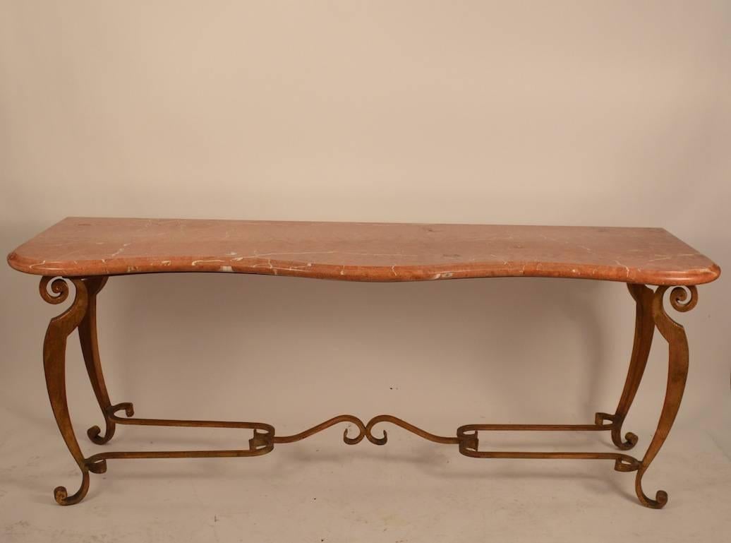 Stylish marble top , iron base console, lobby, serving table, in the manner of Raymond Subes. The iron base is faux gilt, the top is rouge marble.  Elegant and functional  design and scale.