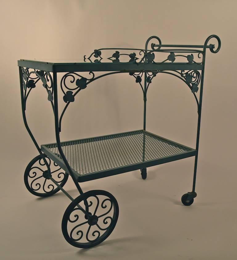 Wrought iron and glass trolley cart by Salterini, suitable for indoor or outdoor use. Two tiers , the top is plate glass, the bottom, metal mesh. Faux Verdi Gris finish, original ready to use condition. 