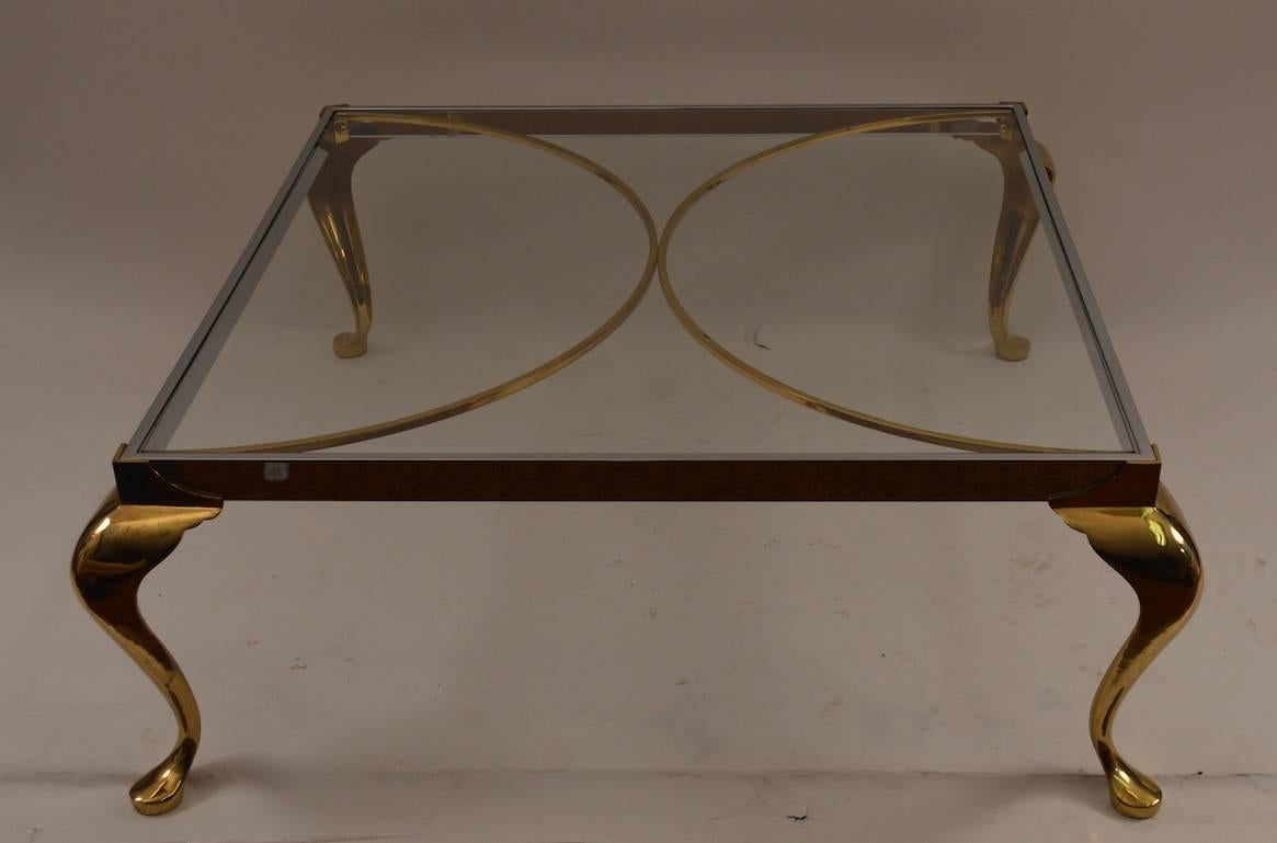 Interesting use of two metals together create an elegant and sophisticated form cocktail, coffee table. Regency influence, Italian made glass top table. Dimensions in listing are for the top, to outside including cabriole leg 39