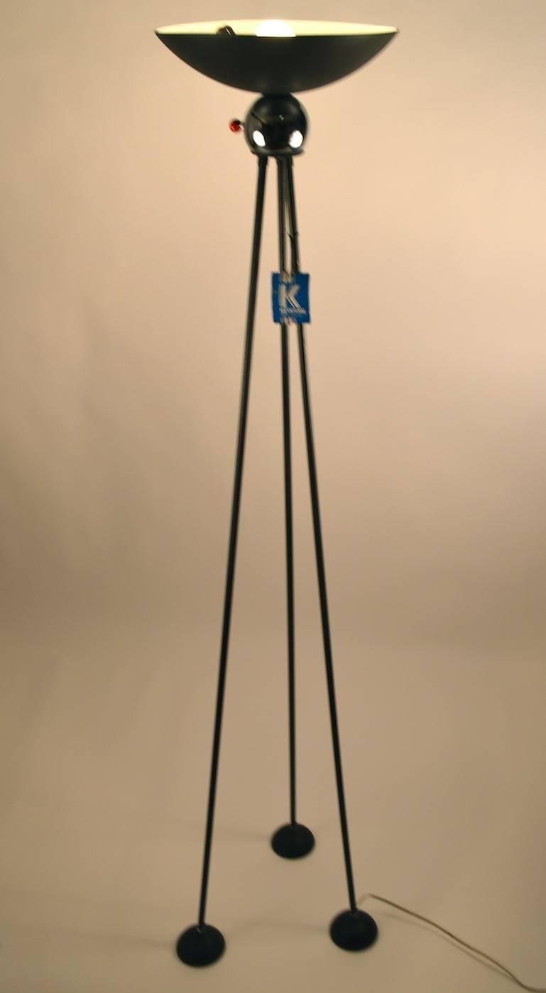Interesting tripod form torchiere, this lamp predates the later Halogen versions of Post Modern lighting design more often seen. Original, clean, and working condition.  This example still retains the original paper manufactures tag, as shown. The