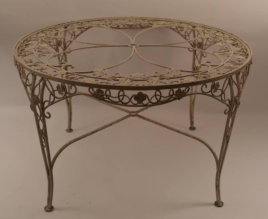 Very ornate foliate pattern, this round dining table seats four ( we have also listed the chairs separately ). Table showing without glass top, we do have the original  glass, included in purchase. Wrought iron table suitable for indoor or outdoor