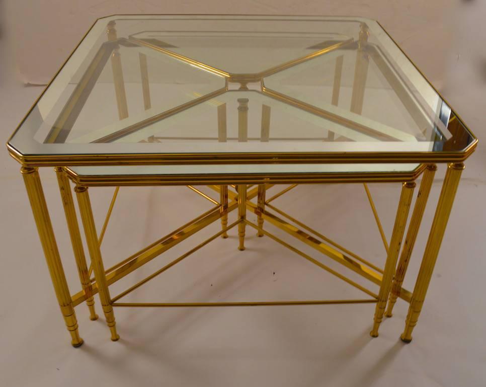 Nice classical Hollywood Regency brass frame coffee / cocktail table, with four tri angular occasional tables which nest under the square master table. The glass tops have a silver mirror trim edge, all glass is original and in good condition. Side