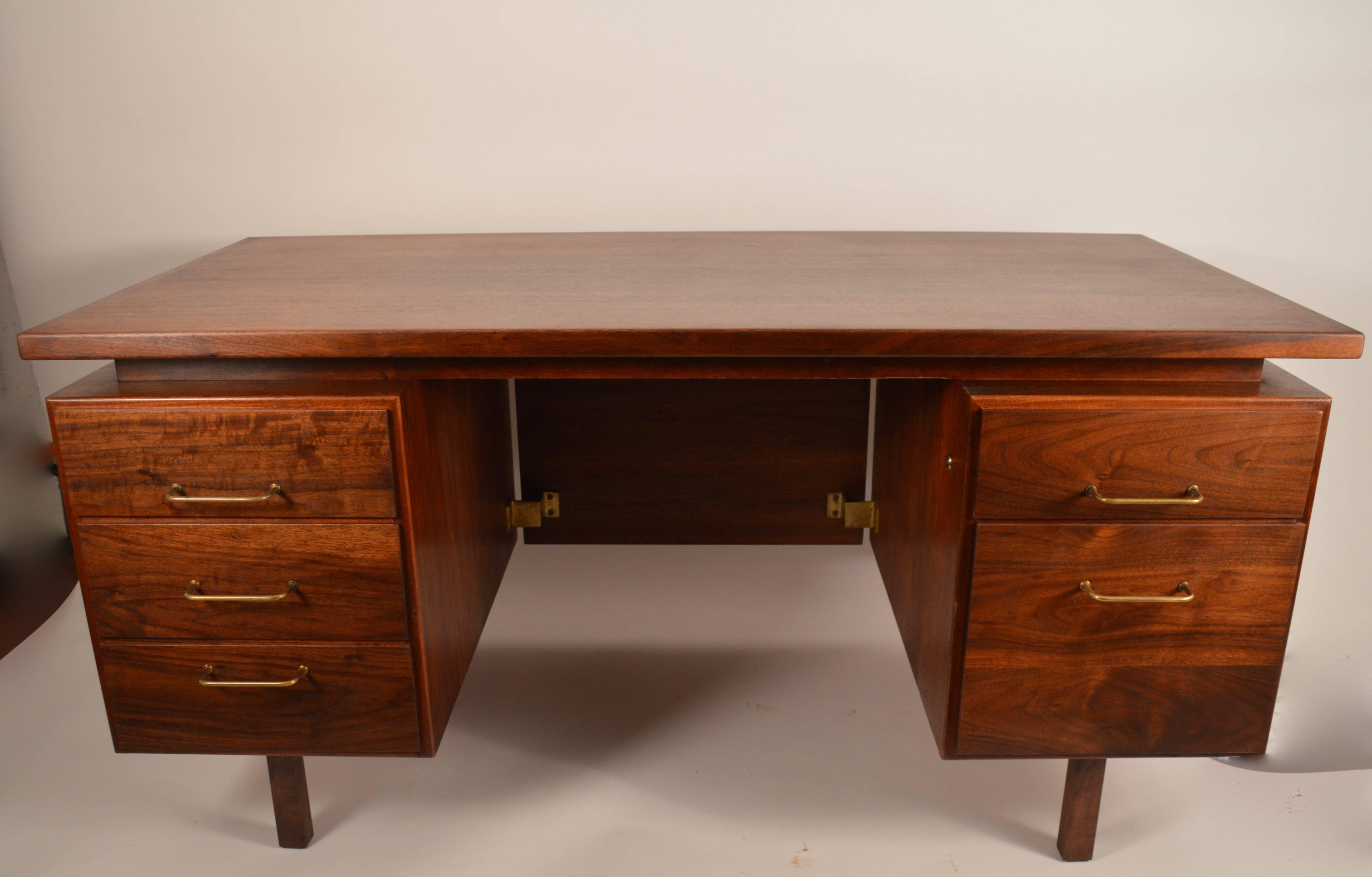 Very nice Jens Risom desk, in walnut. Newly refinished, floating top, five drawers on raised squared legs. Classic Mid-Century desk, large enough for an office space, while small enough for home use.