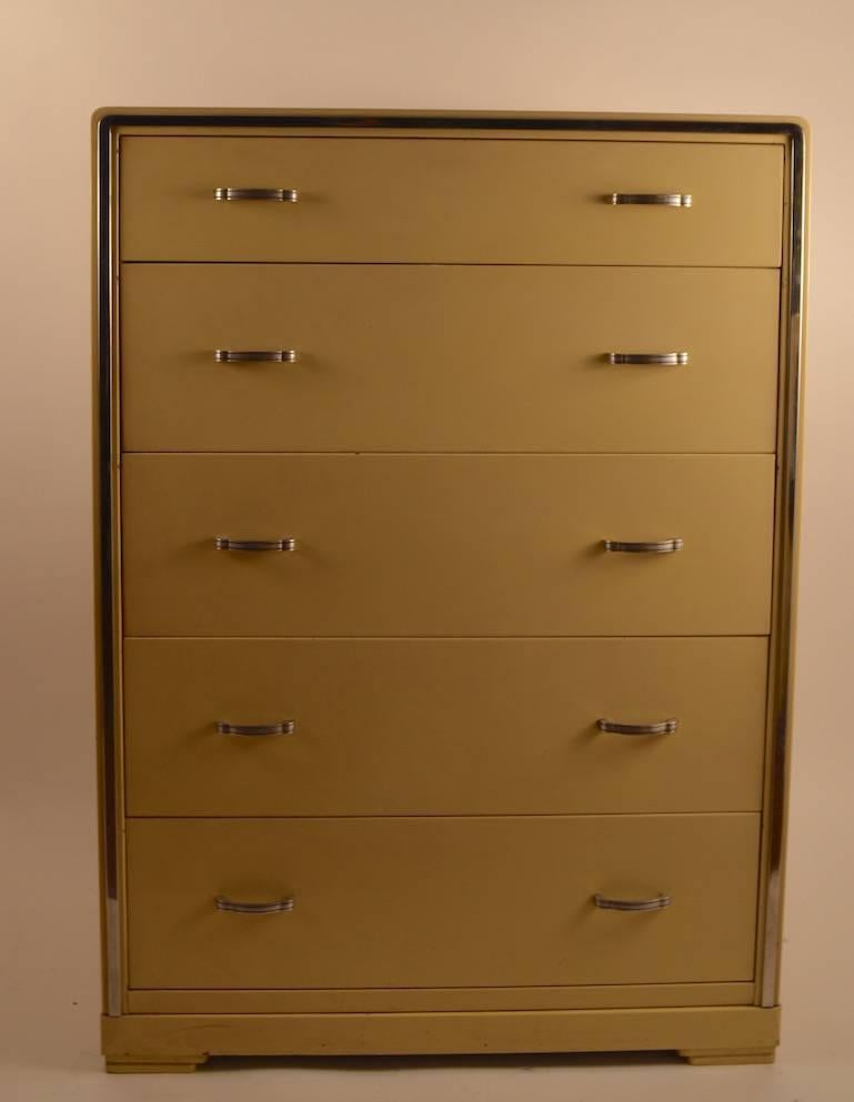 Nice high boy chest by Bel Geddes for Simmons. Pale yellow case with bright chrome trim, and metal pulls. Five deep drawers provide ample storage, overall very fine condition with only slight chipping and wear to finish.
 This Art Deco, Machine