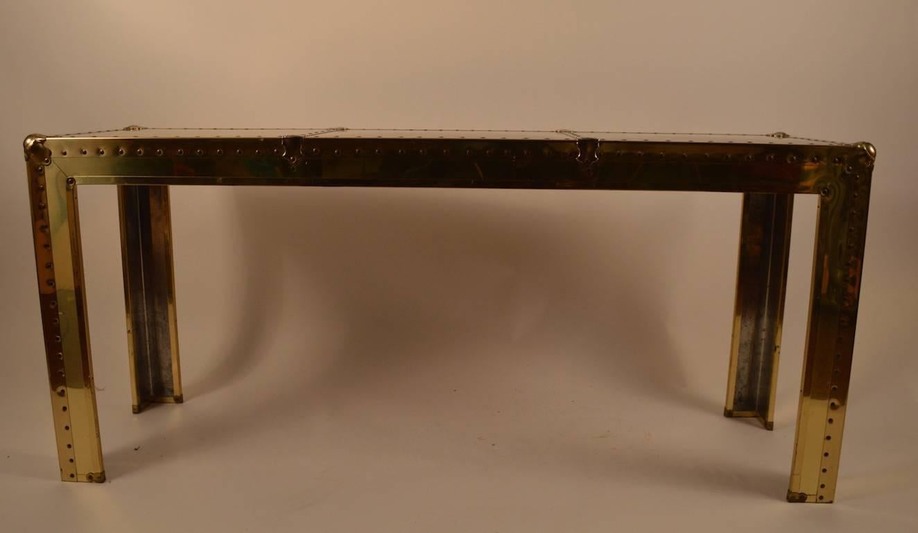 Hard to find form, brass faced console by Sarreid of Spain. This example shows wear to the finish, scratching and spots on the top, normal and consistent with age.