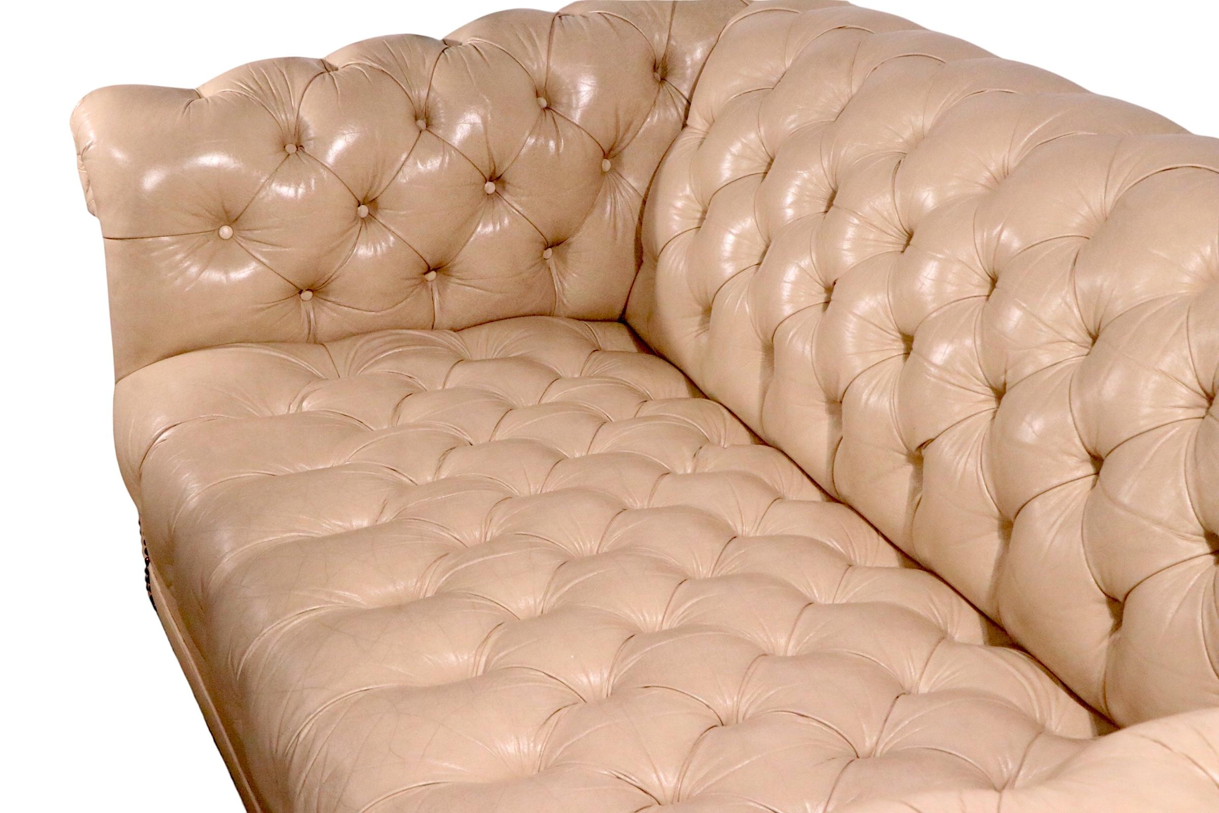 Exceptional pair of vintage leather Chesterfield sofas, in very fine, original, clean and ready to use condition. The sofas feature tufted light tusk colored leather, mounted on solid wood bun feet. Hard to find vintage a leather Chesterfield in