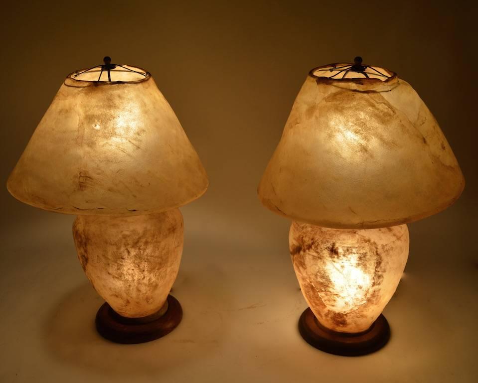 Pair of arts and crafts period lamps. These interesting lamps have hide shades and bodies, the lamps each have interior sockets in addition to the standard socket on th top of the base. 
 The lamps can be used with the top and/or interior sockets