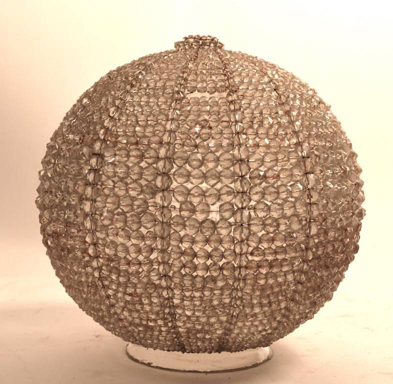 Large clear glass ball with faceted solid glass beads wired over the underlaying globe. The wires which constitute the structure has some surface rust, consequently, there is a brownish tint to the fixture, as shown. Also, there is one small