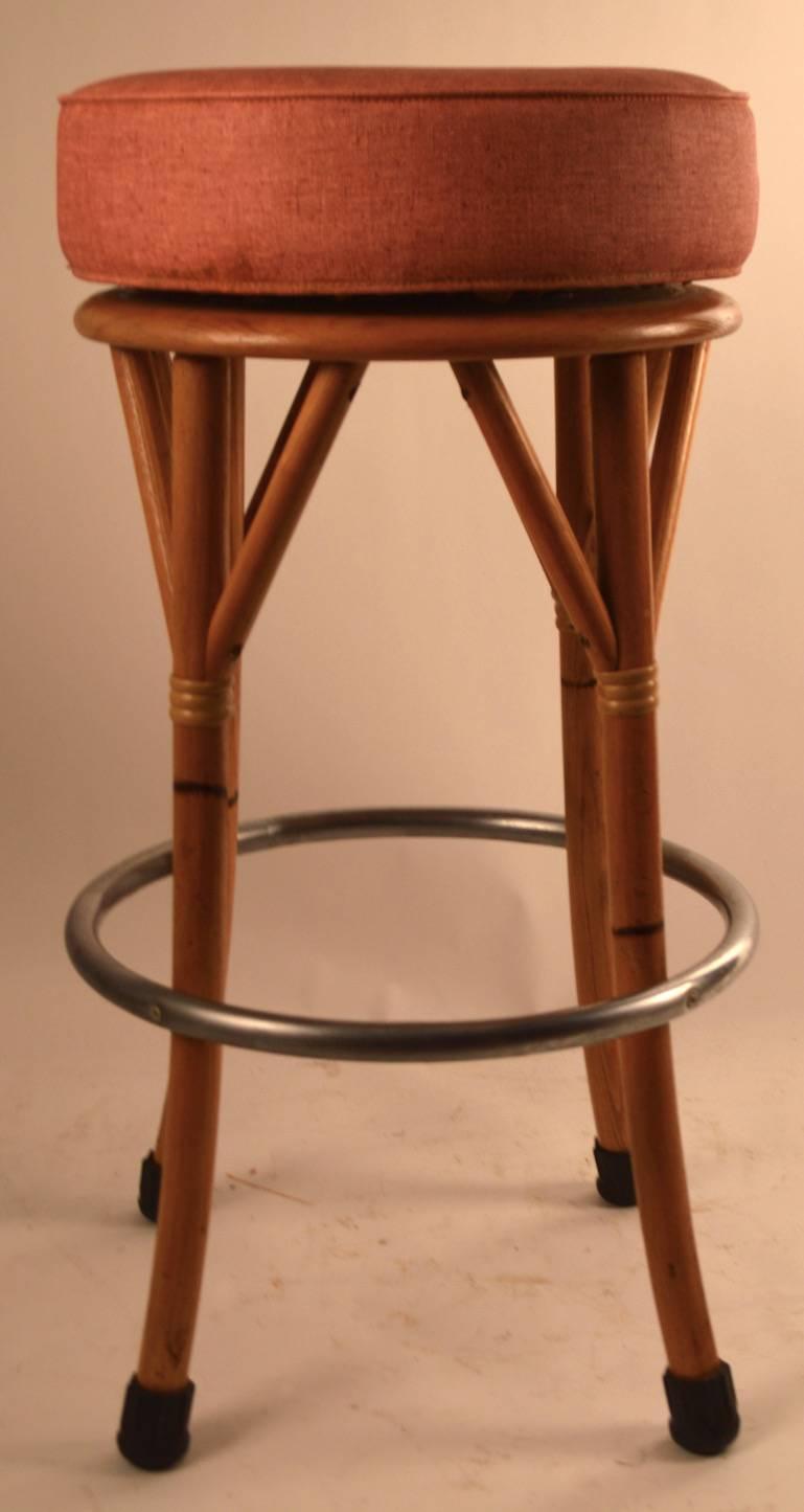Salmon color vinyl pad seat, four faux bamboo oak stools. Seats spin to adjust position, all are in great original condition, one has very slight loss to wood trim seat support as shown. Hard to find sets of six, especially in this condition.