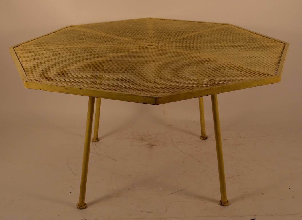 Classic Russel Woodard six sided mesh top outdoor dining table. This example is in original yellow paint finish, which shows wear normal and consistent with age. Great architectural design, quality construction and workmanship, stylish and chic