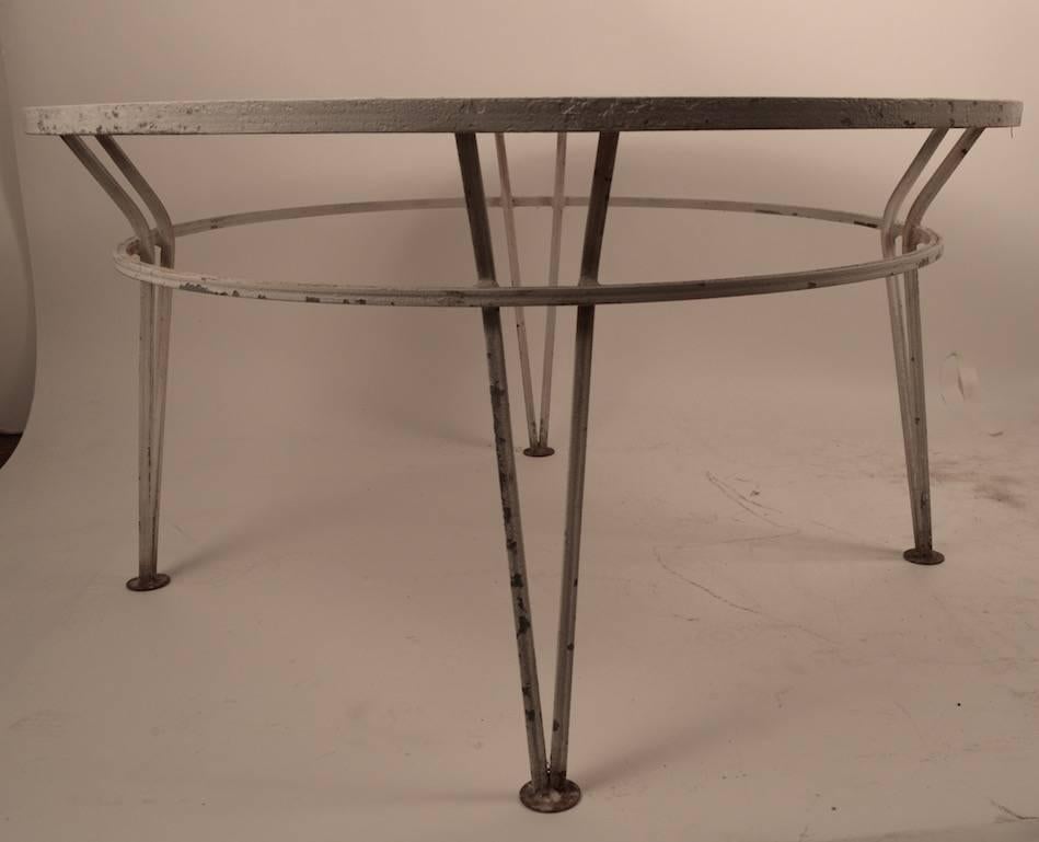 Perfect for a patio, or poolside - low round Salterini cocktail table with wrought iron legs and metal mesh top, white paint finish show wear, normal and consistent with age.